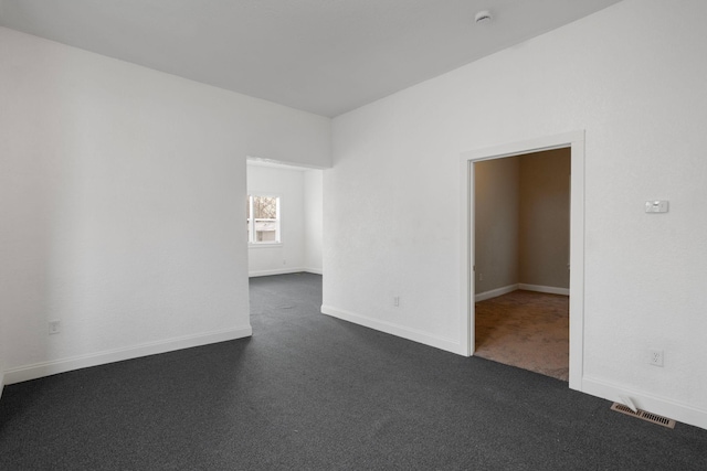 unfurnished room with dark colored carpet