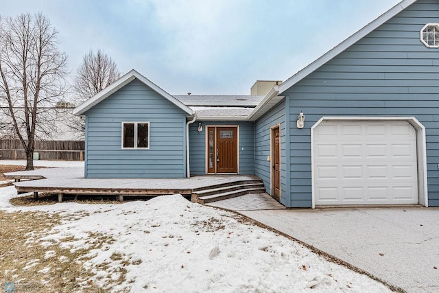 single story home featuring an attached garage, roof mounted solar panels, and fence