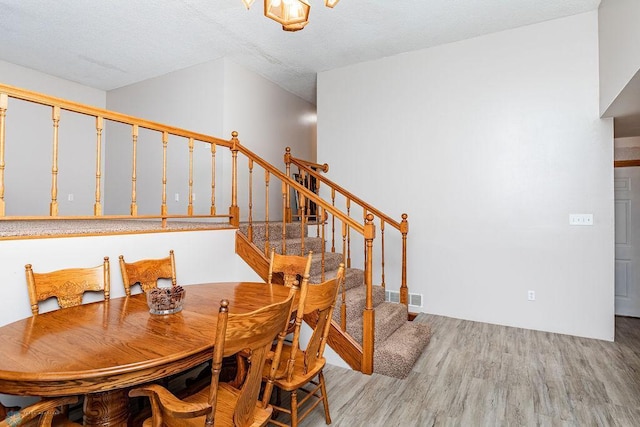 dining area with stairway, visible vents, and light wood-style floors