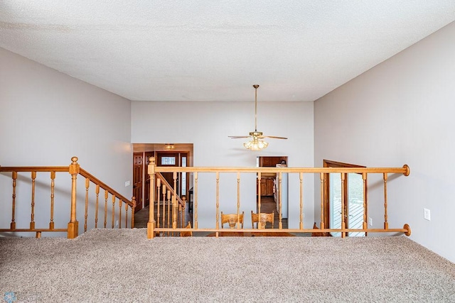 staircase featuring carpet floors and a textured ceiling