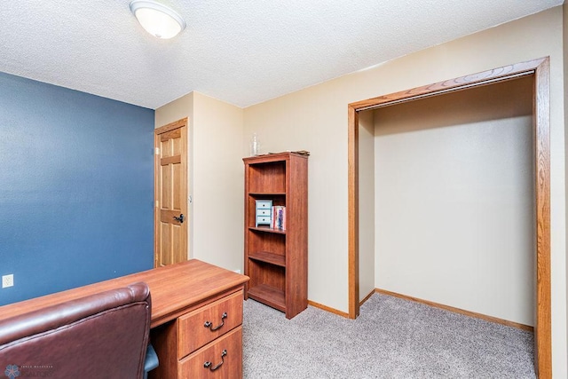 office space featuring light carpet, a textured ceiling, and baseboards