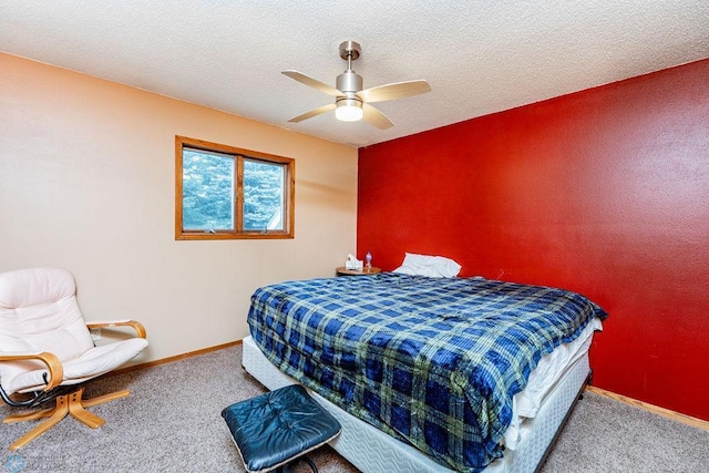 carpeted bedroom with a textured ceiling, a ceiling fan, and baseboards