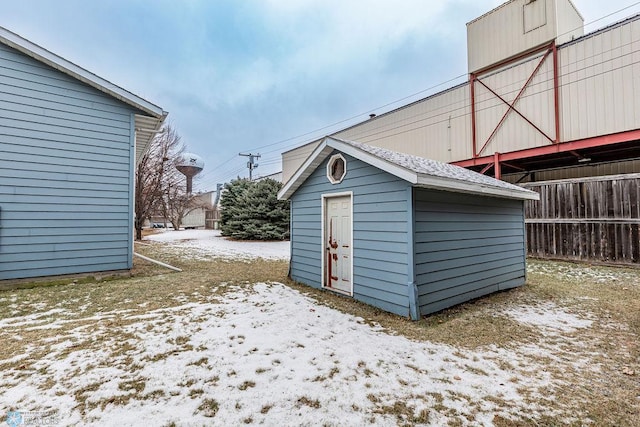 snow covered structure with an outbuilding