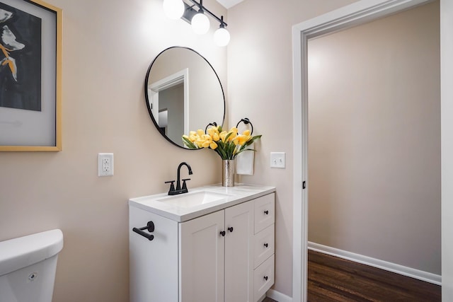 bathroom with vanity, toilet, and wood-type flooring