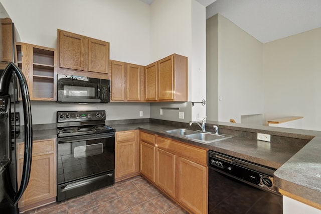 kitchen featuring sink, dark tile patterned floors, and black appliances