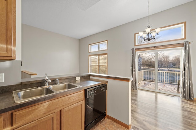 kitchen featuring light wood-type flooring, sink, decorative light fixtures, dishwasher, and a chandelier