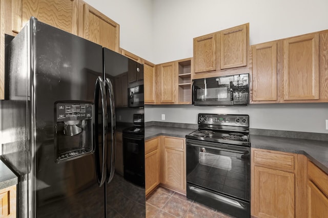 kitchen with dark tile patterned floors and black appliances