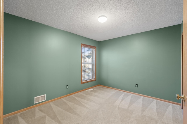 empty room with a textured ceiling and carpet floors