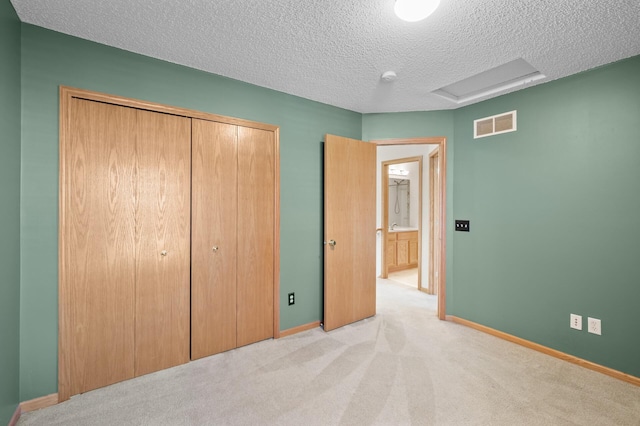 unfurnished bedroom with light carpet, a textured ceiling, and a closet