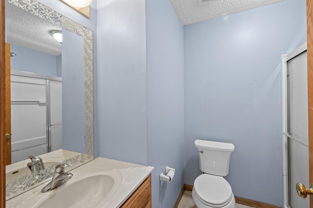 bathroom featuring vanity, toilet, a textured ceiling, and walk in shower