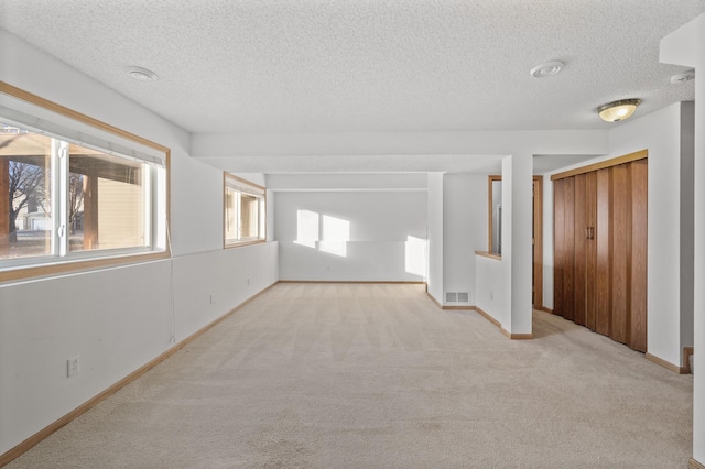 carpeted spare room featuring a textured ceiling