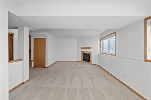 unfurnished living room with a fireplace, a textured ceiling, and light colored carpet