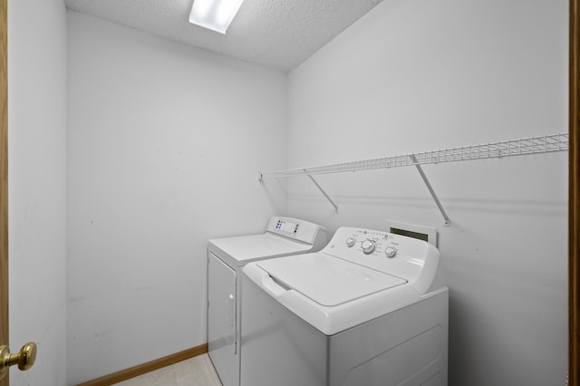 laundry area with a textured ceiling and washing machine and dryer