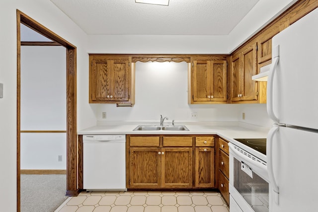 kitchen with a textured ceiling, sink, and white appliances