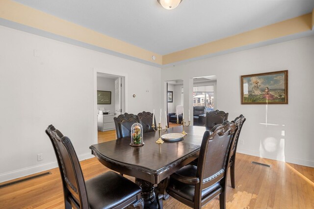 dining space with visible vents, light wood-style flooring, and baseboards