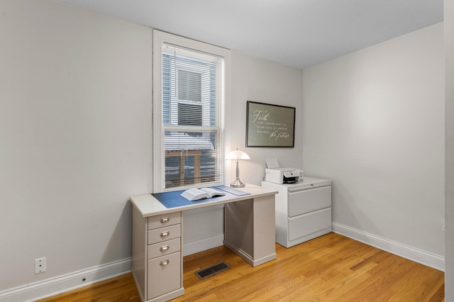 home office featuring visible vents, light wood-style flooring, and baseboards