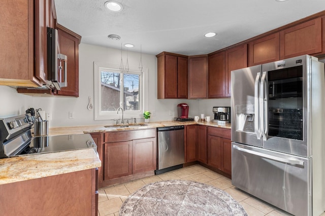 kitchen with light tile patterned floors, appliances with stainless steel finishes, brown cabinets, and a sink