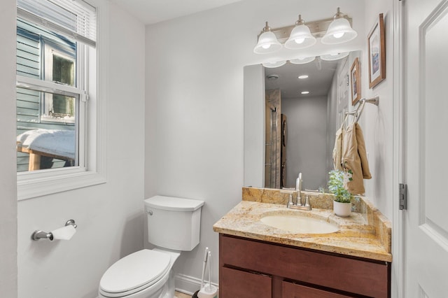 full bathroom with a shower, baseboards, vanity, and toilet