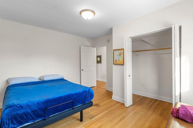 bedroom featuring light wood-type flooring, a closet, and baseboards