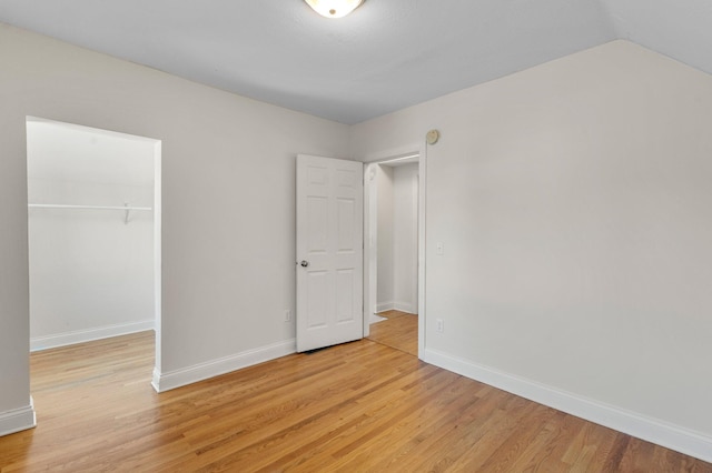 unfurnished bedroom featuring baseboards, a closet, and light wood-style floors