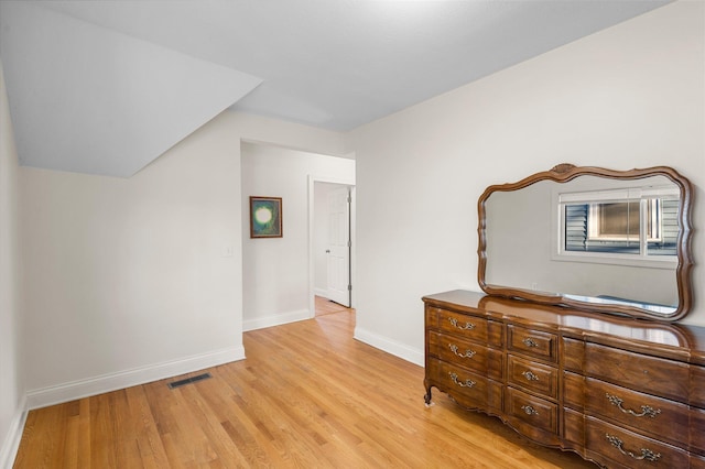 unfurnished bedroom featuring light wood finished floors, baseboards, and visible vents