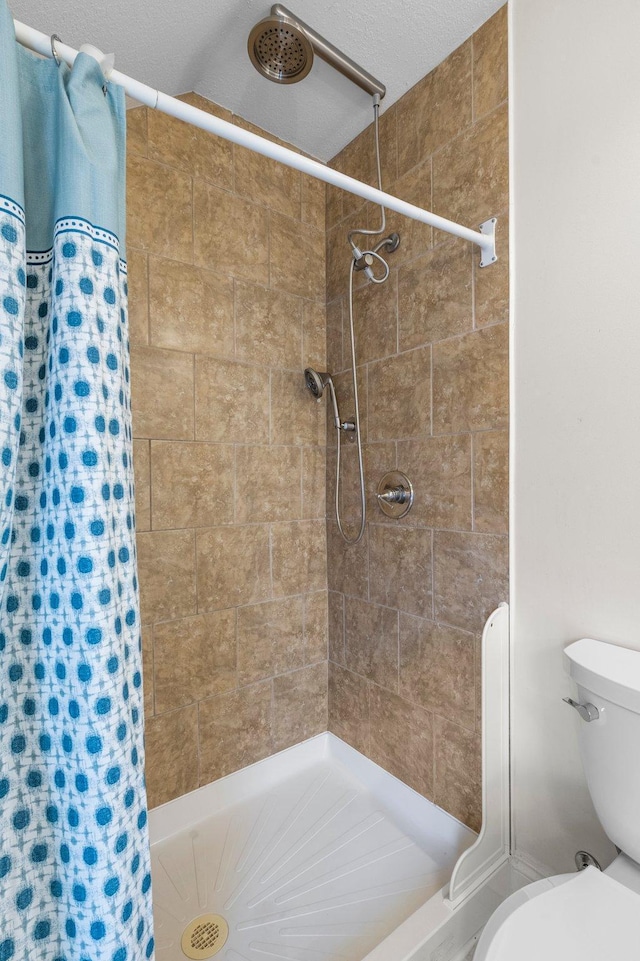 bathroom featuring a shower stall and toilet