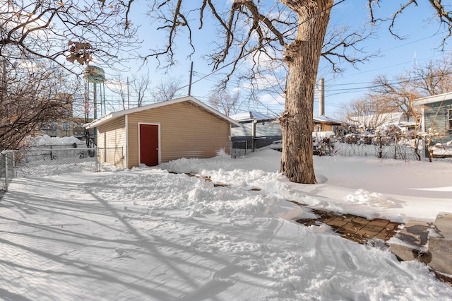 yard layered in snow with fence and an outbuilding