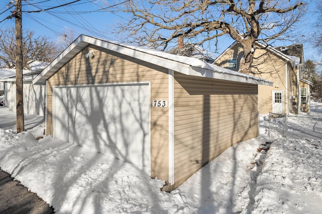 snow covered garage featuring a garage