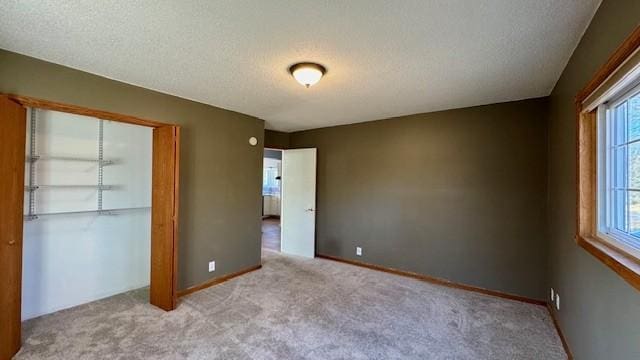 unfurnished bedroom featuring a closet, light colored carpet, and a textured ceiling