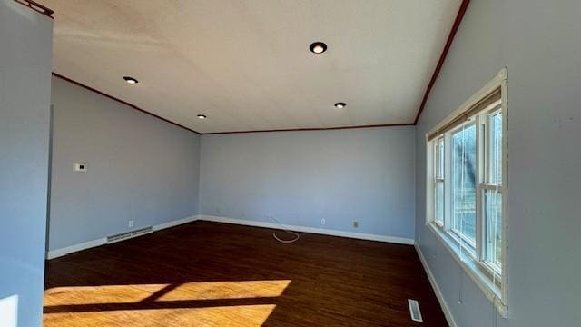 empty room with lofted ceiling, crown molding, and dark wood-type flooring