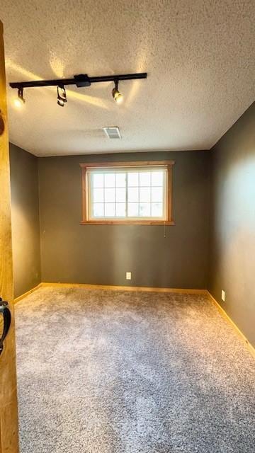 carpeted spare room featuring a textured ceiling