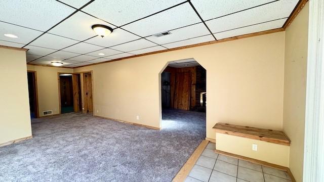 unfurnished room with a drop ceiling and light colored carpet