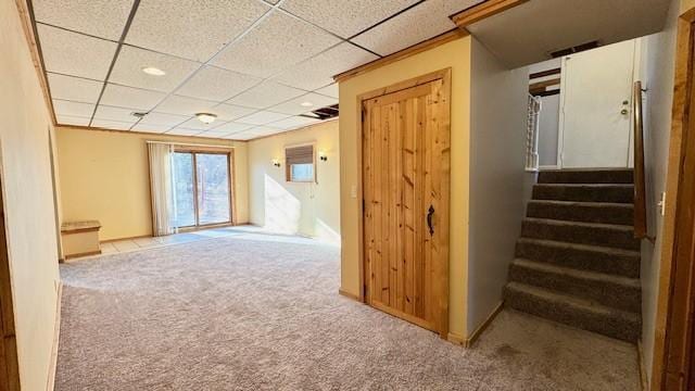 interior space featuring a drop ceiling and light colored carpet