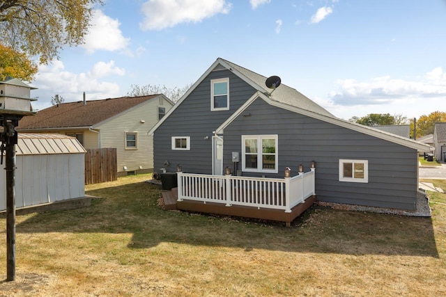 rear view of house with a yard, a storage unit, and a wooden deck