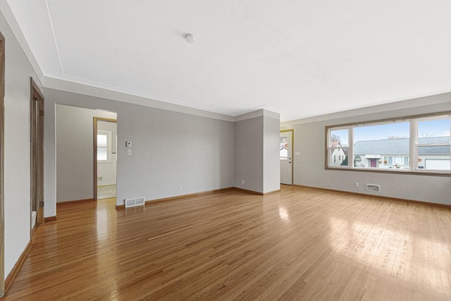 unfurnished living room featuring light hardwood / wood-style floors and ornamental molding