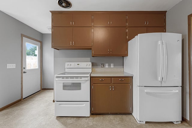 kitchen featuring light carpet and white appliances