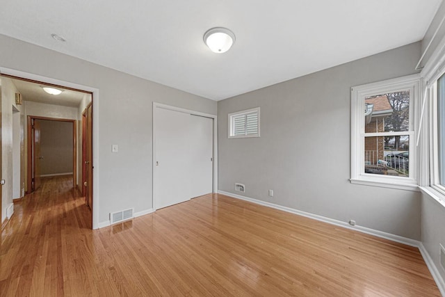 unfurnished bedroom featuring light wood-type flooring and a closet