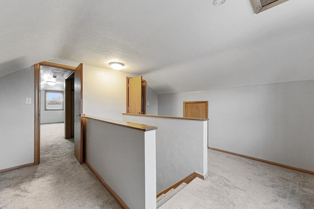 additional living space with a textured ceiling, light colored carpet, and lofted ceiling