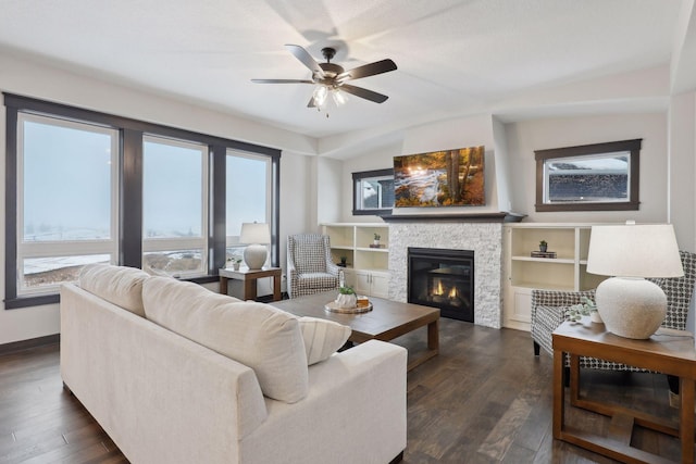 living room featuring ceiling fan, vaulted ceiling, a fireplace, and dark wood-type flooring