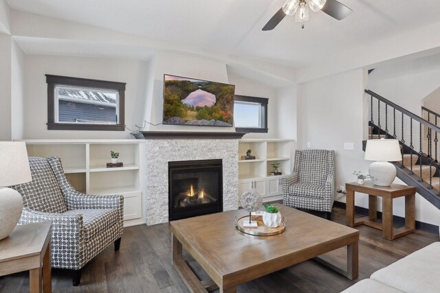 living room featuring a stone fireplace, ceiling fan, dark hardwood / wood-style flooring, and lofted ceiling