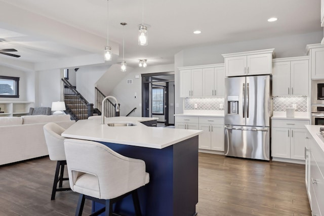 kitchen with a breakfast bar area, white cabinetry, a kitchen island with sink, and appliances with stainless steel finishes