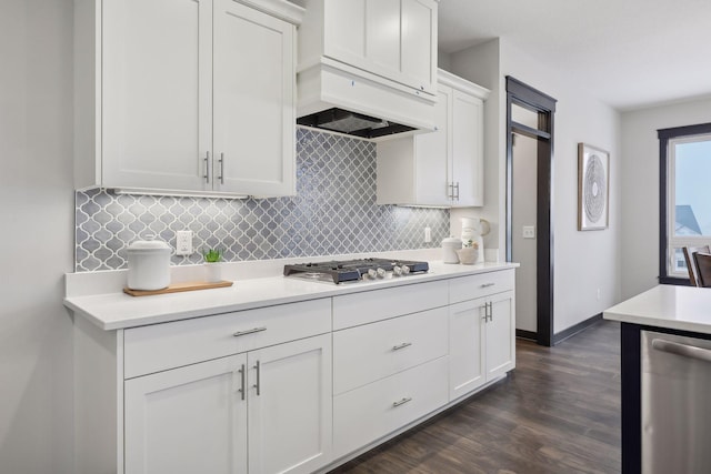 kitchen with dark hardwood / wood-style flooring, premium range hood, decorative backsplash, white cabinets, and appliances with stainless steel finishes