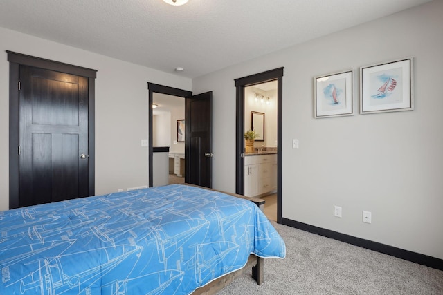 carpeted bedroom with a textured ceiling and ensuite bathroom