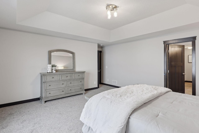 carpeted bedroom featuring a tray ceiling