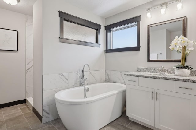 bathroom with separate shower and tub, tile walls, vanity, and a textured ceiling