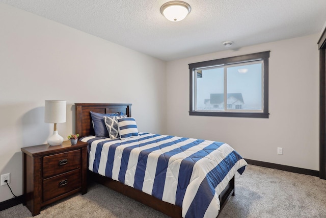 bedroom with a textured ceiling and light carpet