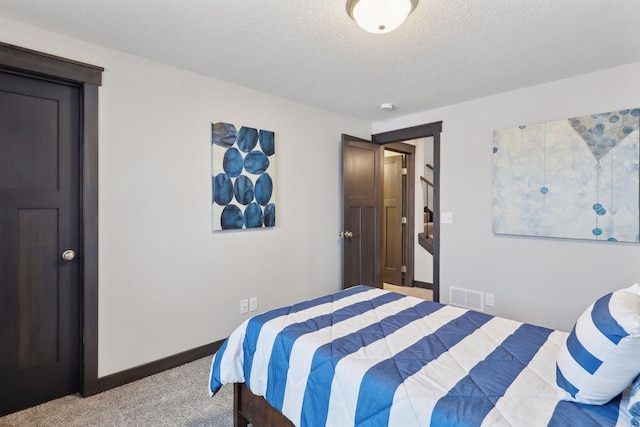 bedroom featuring light colored carpet and a textured ceiling