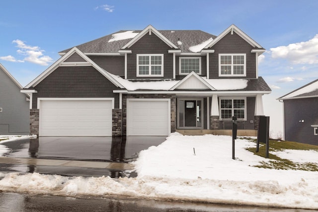 craftsman-style home featuring driveway and stone siding