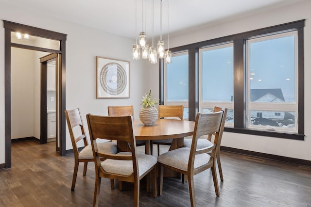 dining room featuring an inviting chandelier, baseboards, and dark wood-type flooring