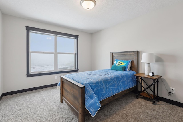 bedroom with a textured ceiling, carpet floors, and baseboards